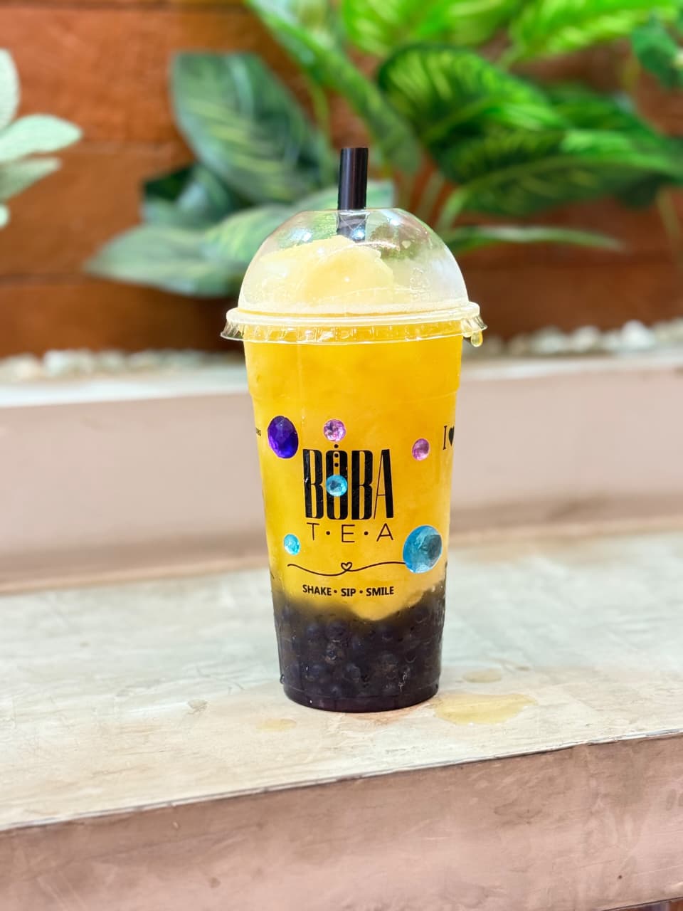 Bebida amarilla de Bōba Tea con perlas oscuras