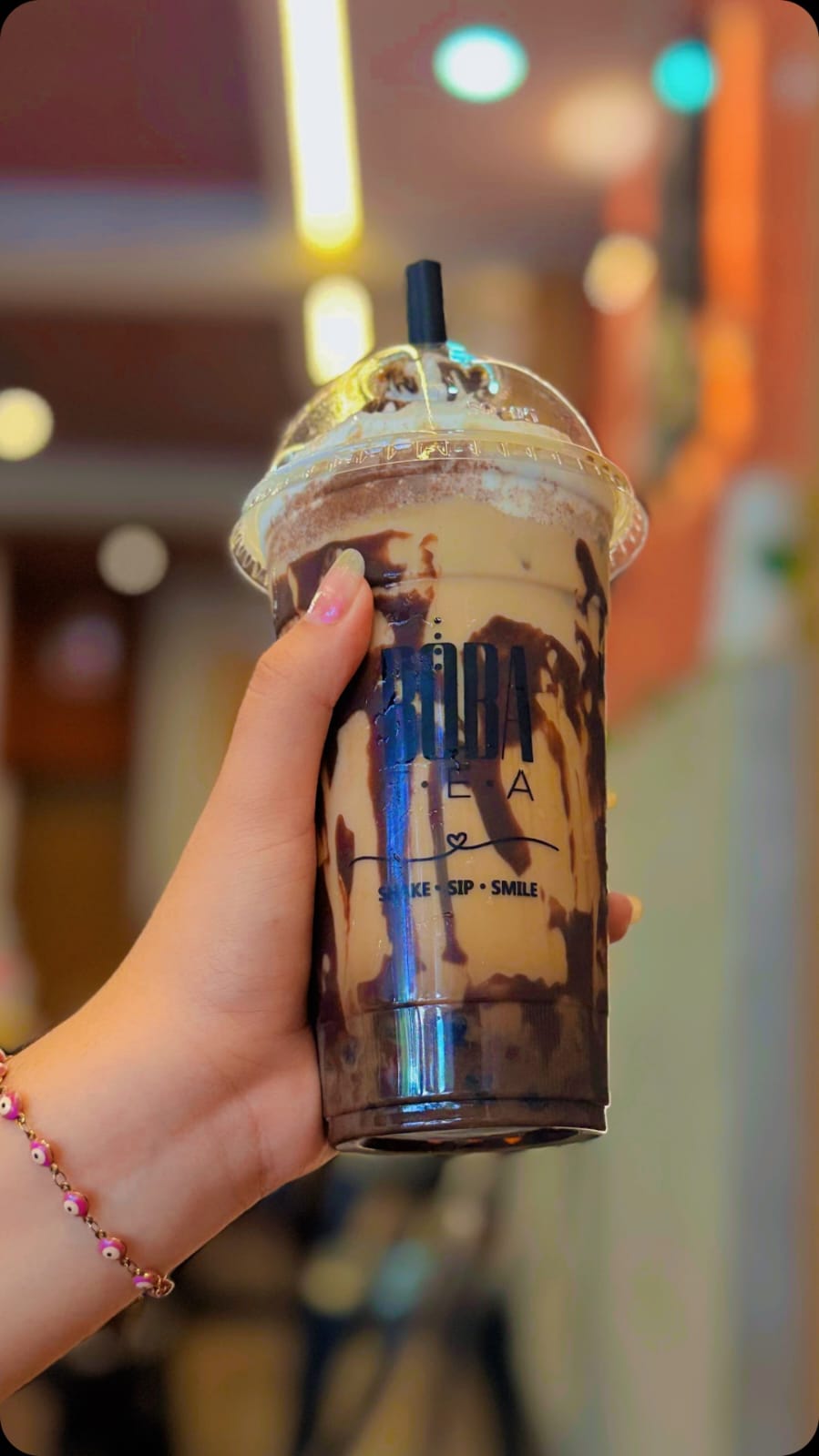 Vaso de Boba Tea con chocolate y perlas, sostenido en la mano